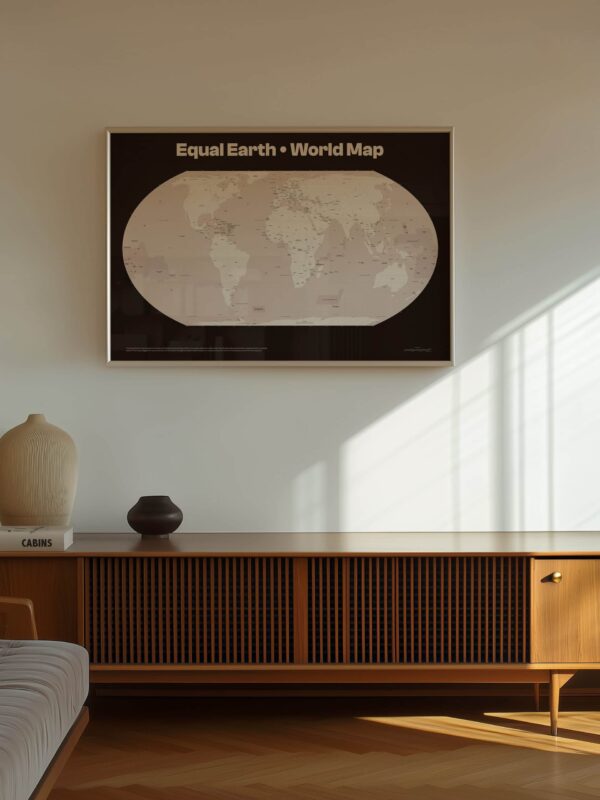A large wall print of the Equal Earth world map projection, framed in a sleek design, displayed above a wooden sideboard in a bright room with natural light.