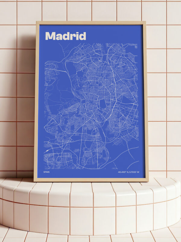 The Madrid City Map Poster features a vibrant blue background with white line art detailing the map of Madrid, framed in a light wood frame. Ideal for decor in urban-themed spaces.
