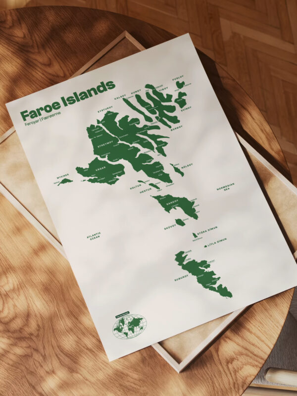 A map of the Faroe Islands, featuring green illustrations of the islands and their names, displayed on a wooden table with a textured surface.