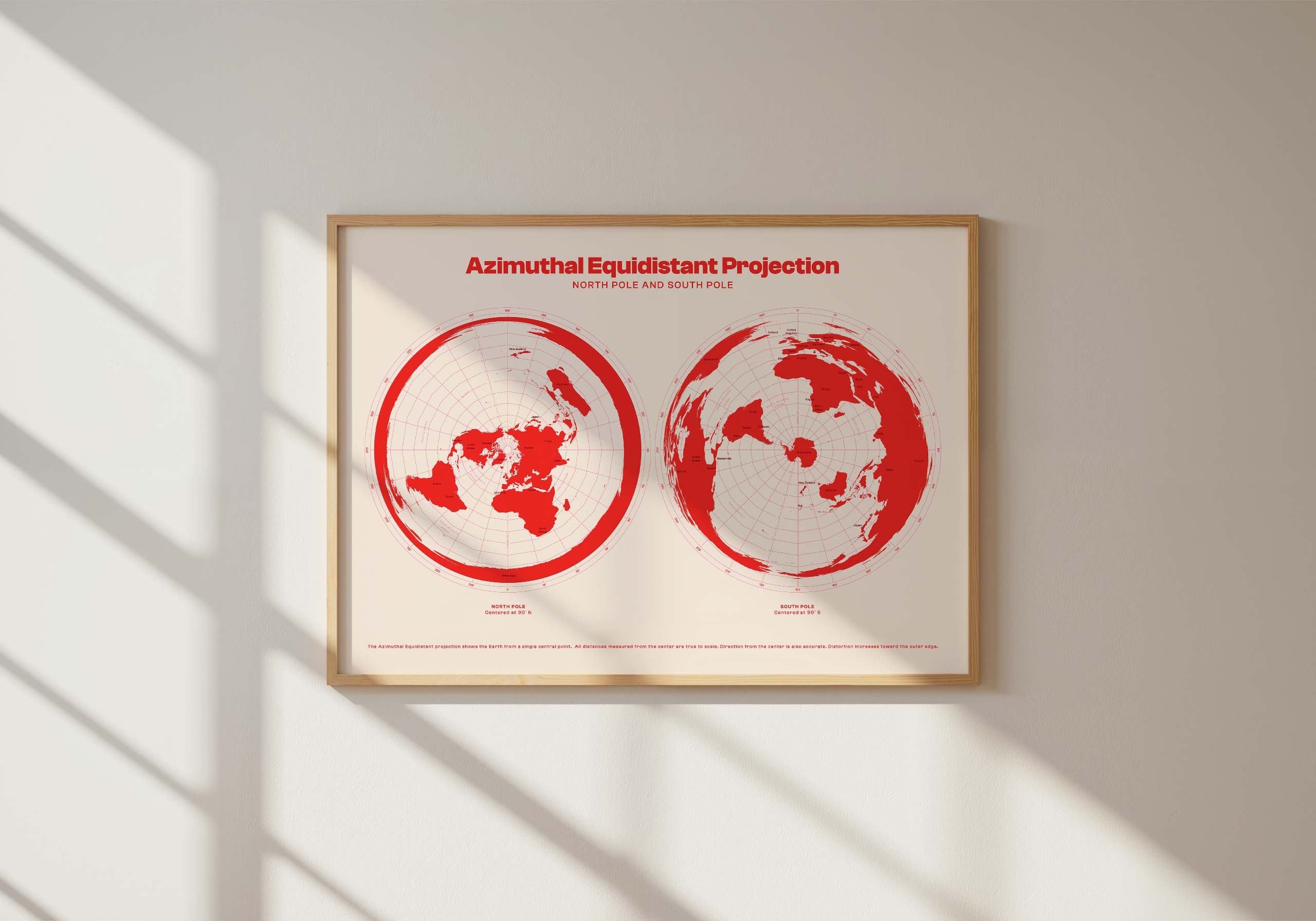 Framed azimuthal equidistant projection world map print hanging on white wall