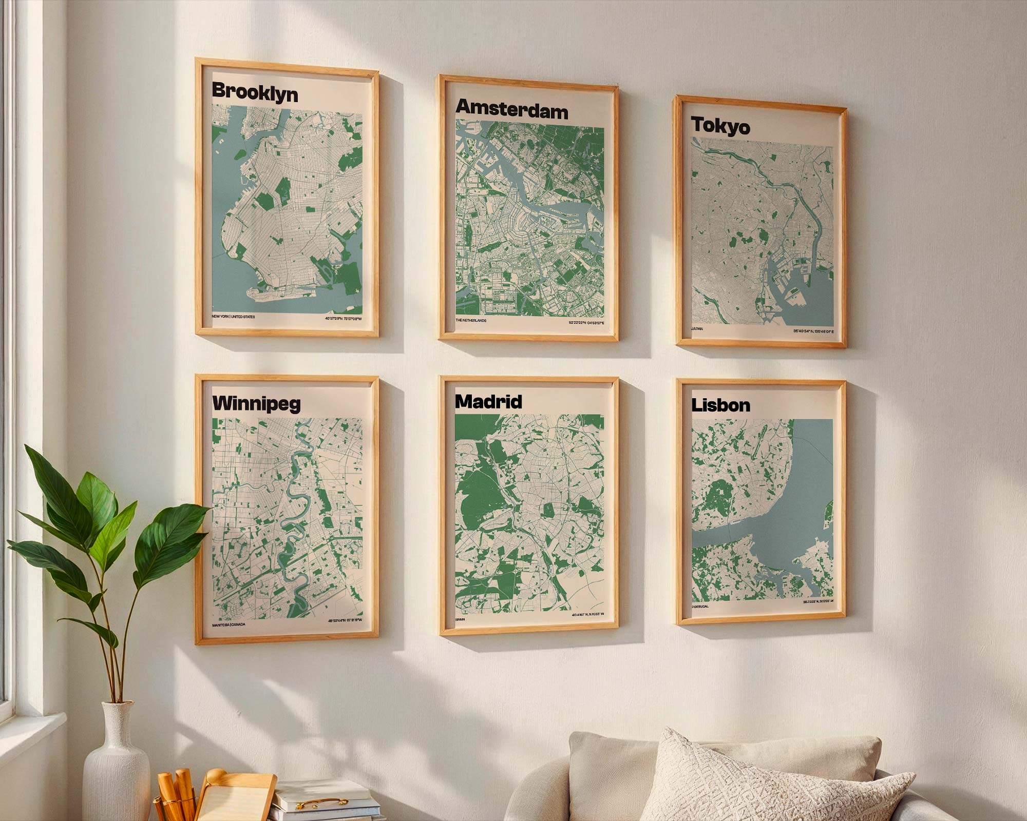Six framed city map prints displayed on white wall above couch