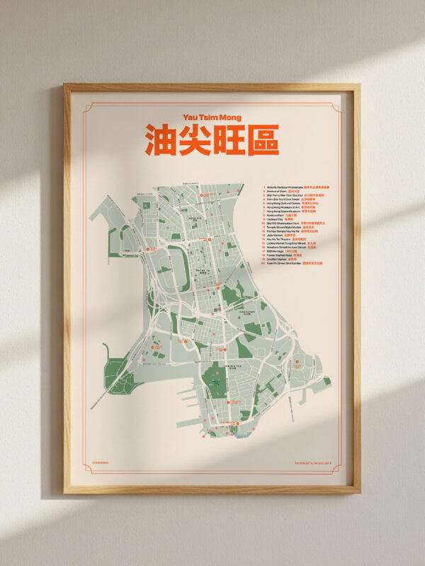 Yau-Tsim-Mong-2 A framed map of a district, featuring green areas and road layouts, hanging on a wall with natural light casting shadows. The map has colorful text and labels indicating locations.