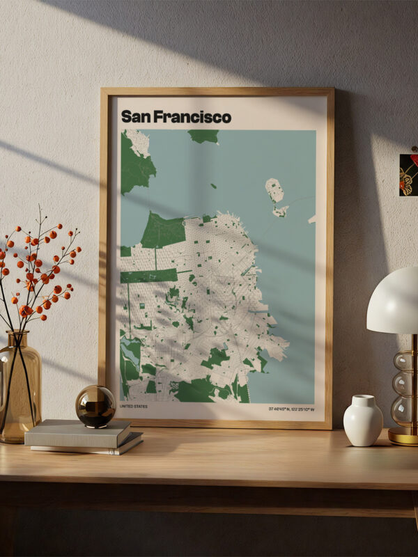 A framed map of San Francisco features shades of green and white, displaying streets and landmarks. The artwork is positioned on a wooden desk beside a decorative vase of orange berries, a round decorative glass orb, and a modern lamp.
